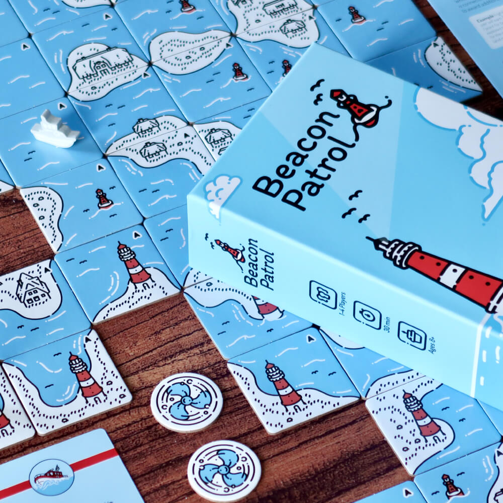 A caixa do jogo de tabuleiro de Beacon Patrol em cima das peças do jogo.